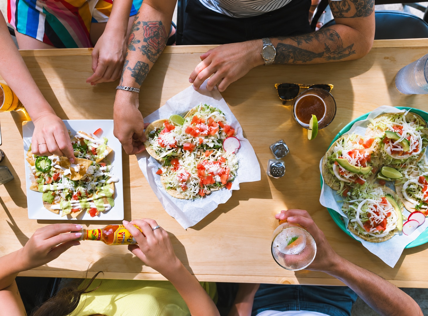 AI-enhanced original photo of friends sharing tacos, nachos, and drinks at Taqueria Portland